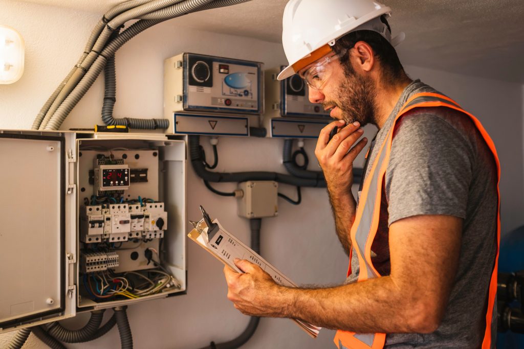 "Engineer Examining a Checklist for Maintenance: Professional Technician Performing a Thorough Inspection"